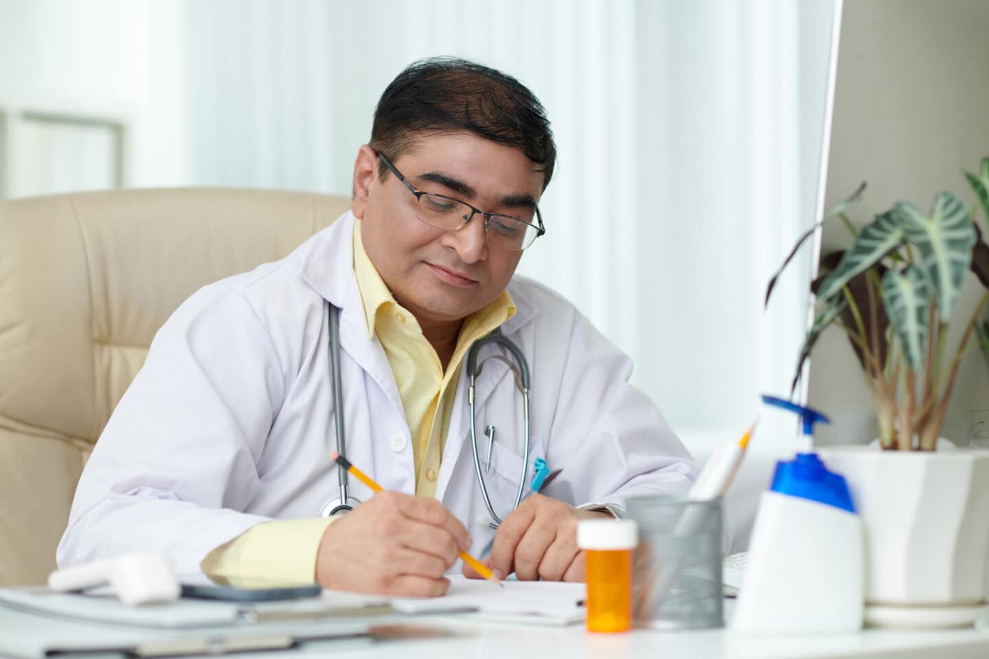 Experienced chief physician signing documents at his desk