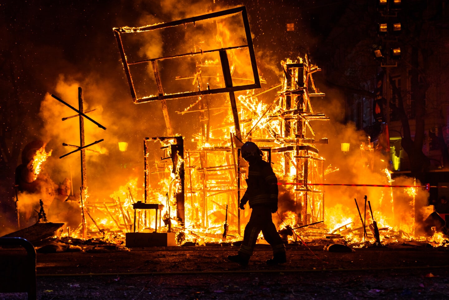 Firefighter with his protective suit working controlling the burning of a Falla during the Valencian fiestas.