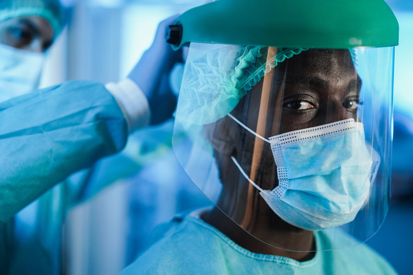 Men doctors at work inside hospital during coronavirus outbreak - Medical worker on Covid-19 crisis wearing face protective mask - Focus on black guy eye