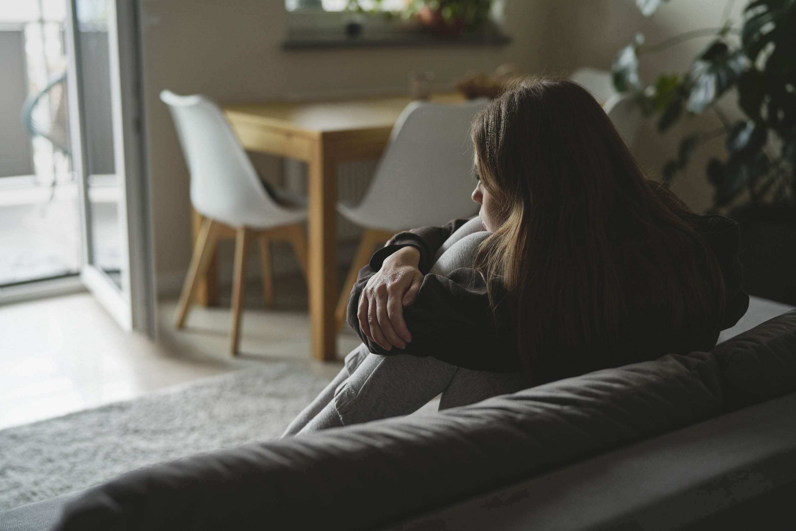 Femme caucasienne triste, assise sur le canapé et souffrant de dépression